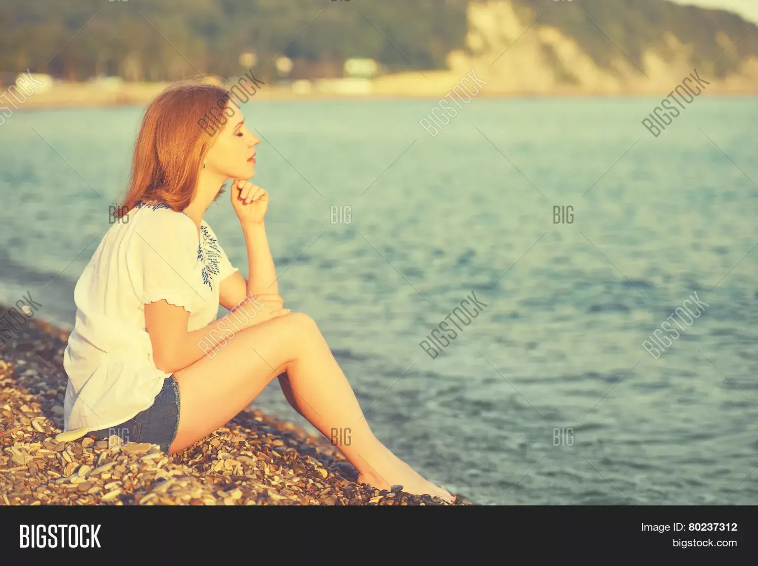 женщина, мечтательно глядящая на море