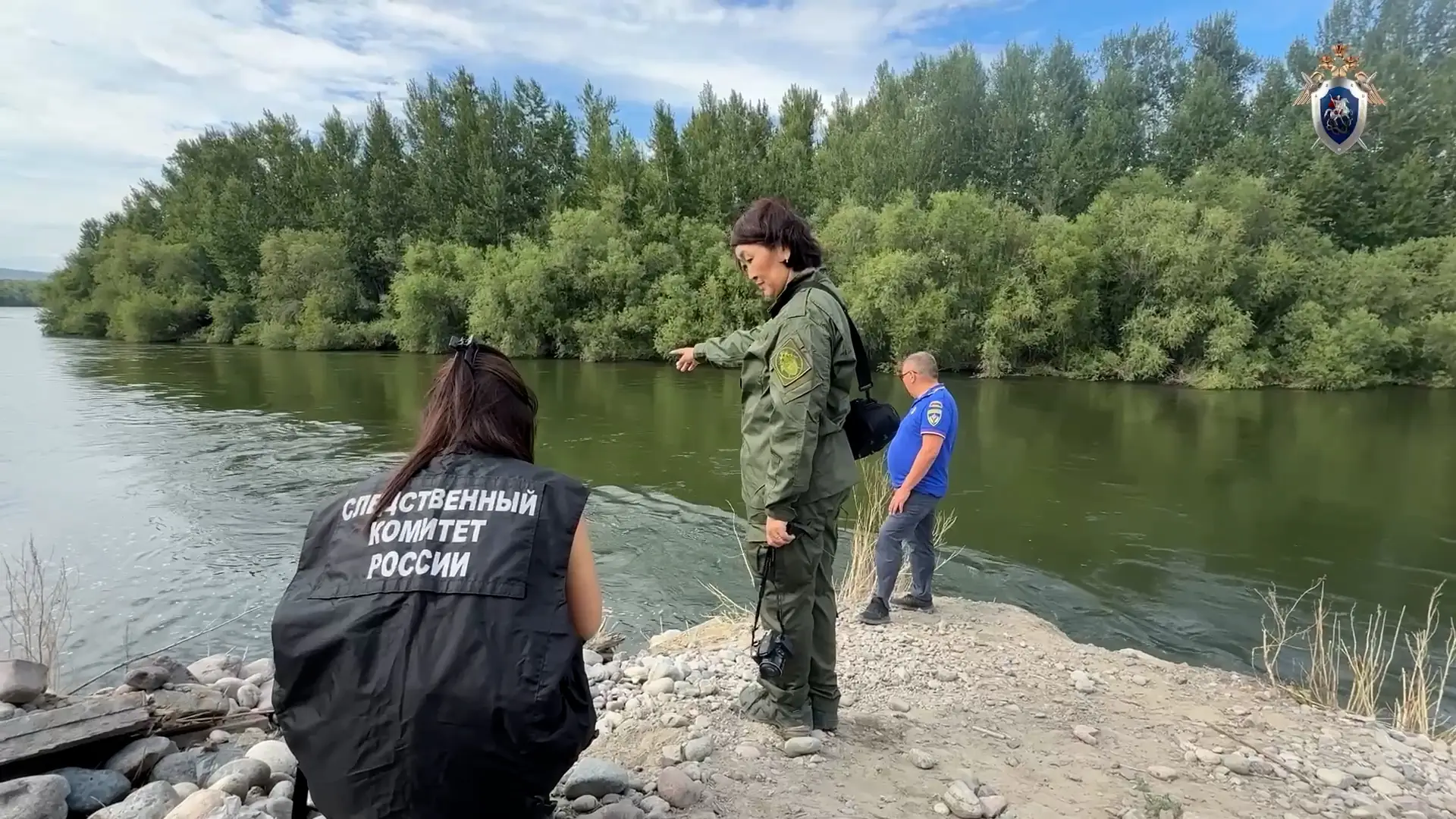 волонтеры в жилетах саянспас ищут на берегу реки